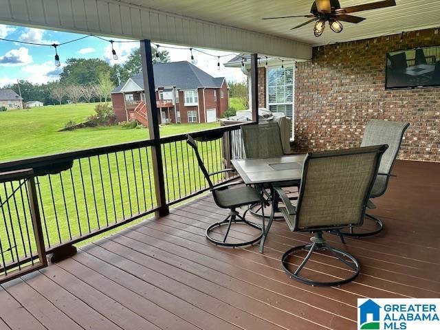 wooden deck featuring a lawn and ceiling fan