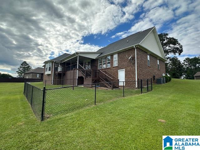 back of property with cooling unit and a yard