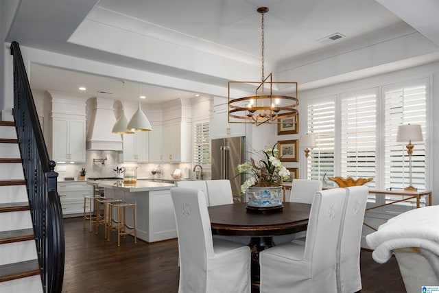 dining area featuring a notable chandelier, dark hardwood / wood-style floors, sink, and a wealth of natural light