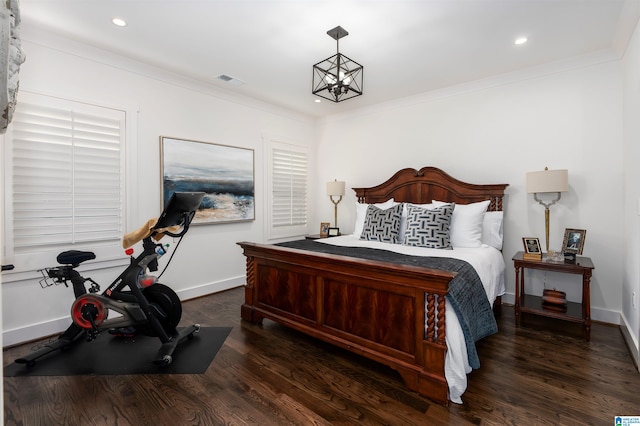 bedroom featuring ornamental molding, dark hardwood / wood-style flooring, and a notable chandelier