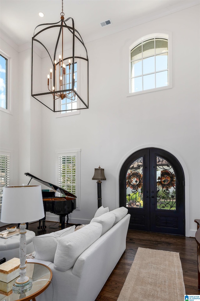 living room featuring an inviting chandelier, dark wood-type flooring, and a healthy amount of sunlight