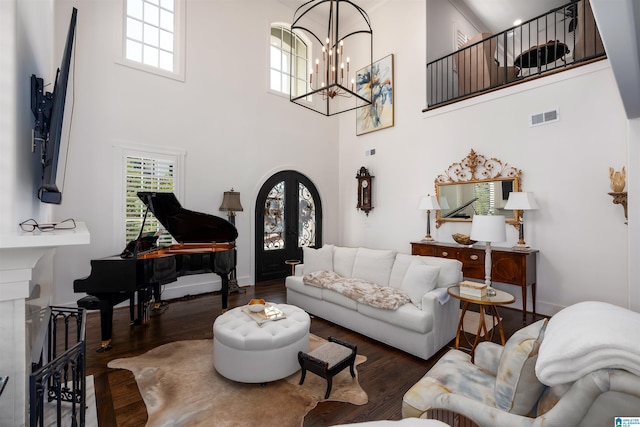 living room with a chandelier, a high ceiling, and dark hardwood / wood-style flooring