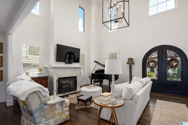 living room with a fireplace, a towering ceiling, and dark hardwood / wood-style flooring