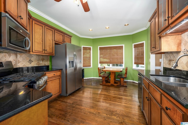 kitchen with appliances with stainless steel finishes, backsplash, dark hardwood / wood-style flooring, and crown molding