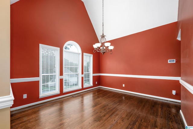 empty room with high vaulted ceiling, a chandelier, and dark wood-type flooring