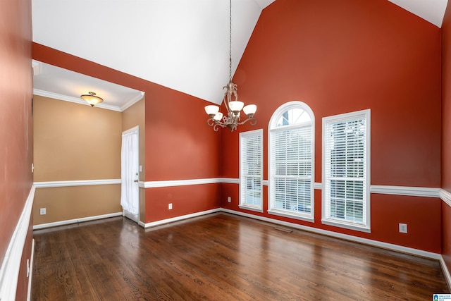 empty room with high vaulted ceiling, a chandelier, dark hardwood / wood-style floors, and crown molding