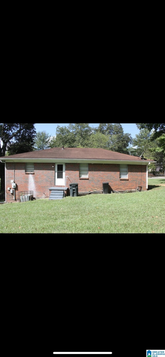 rear view of property featuring a lawn