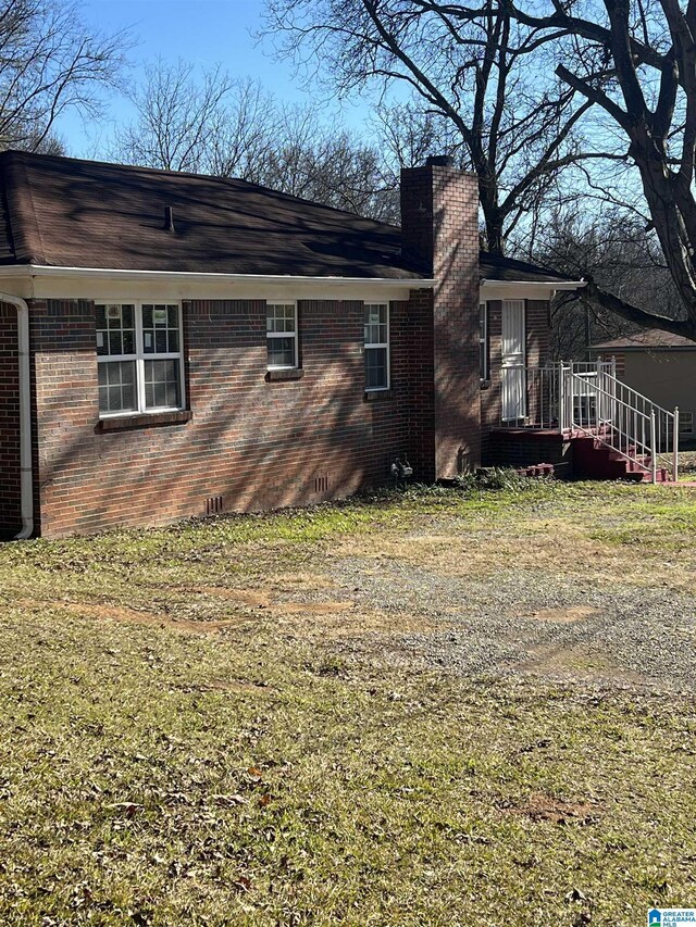 view of side of home with a yard