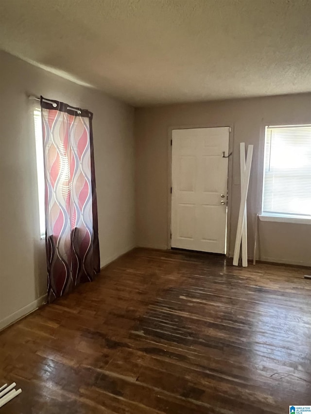 foyer with dark hardwood / wood-style floors and a textured ceiling