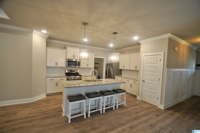 kitchen featuring appliances with stainless steel finishes, a kitchen island with sink, and white cabinets