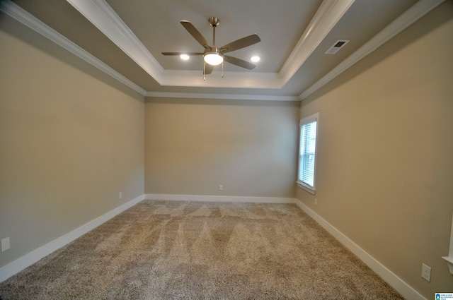 carpeted empty room featuring a raised ceiling, ornamental molding, and ceiling fan