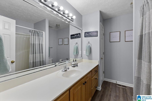 bathroom featuring a textured ceiling, toilet, hardwood / wood-style flooring, vanity, and a shower with shower curtain