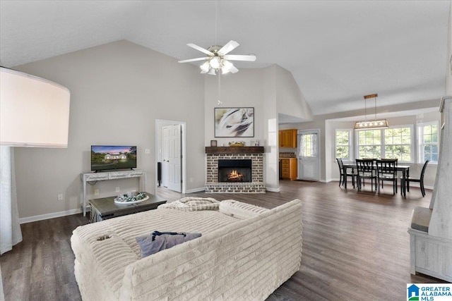 living room featuring a fireplace, ceiling fan, dark hardwood / wood-style flooring, and high vaulted ceiling