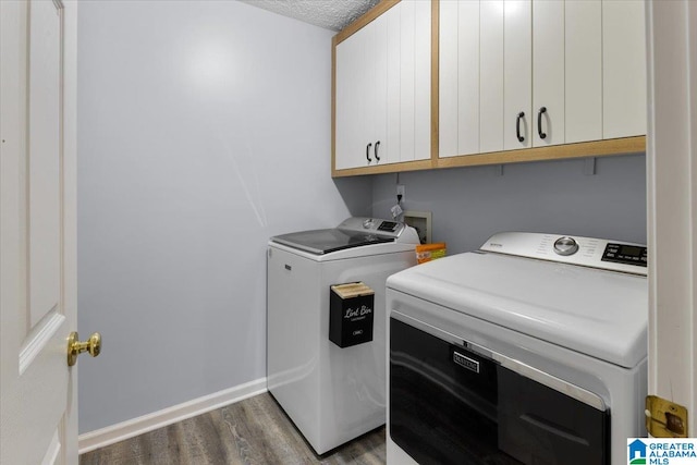 washroom with washer and dryer, dark hardwood / wood-style flooring, cabinets, and a textured ceiling