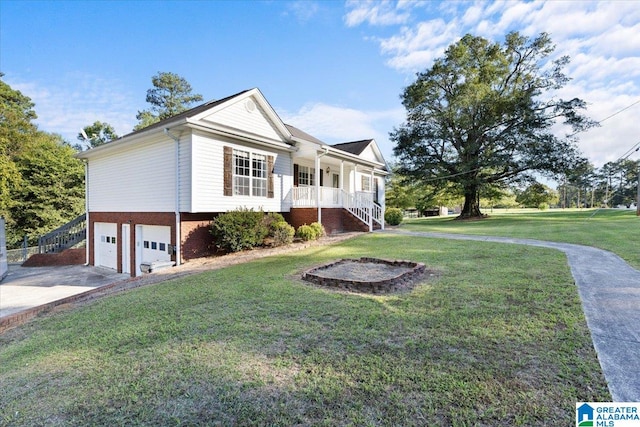 view of front of house featuring a porch, a front yard, and a garage