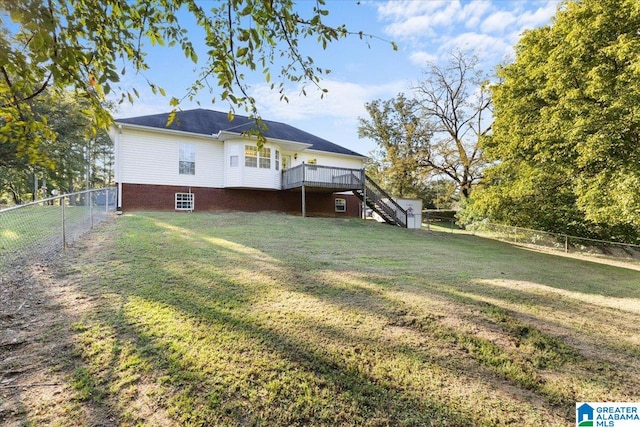 back of property with a yard and a wooden deck