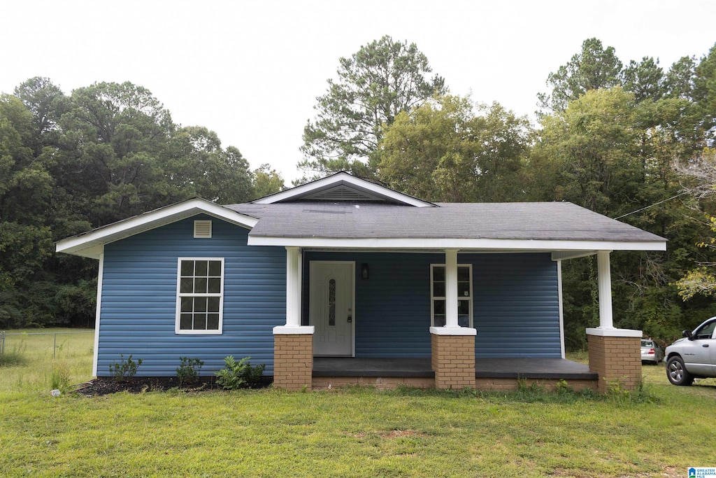 view of front facade featuring covered porch and a front yard