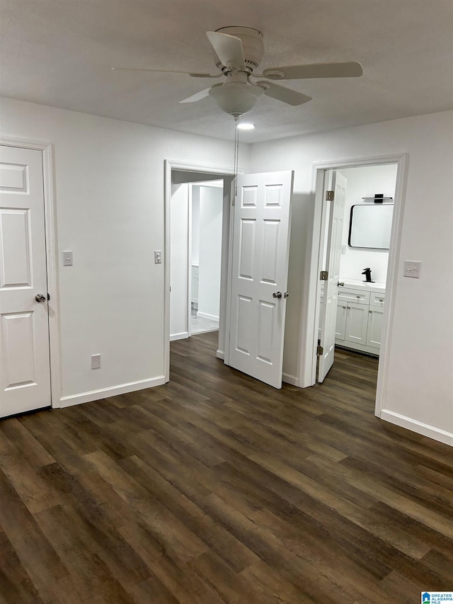 unfurnished bedroom featuring dark hardwood / wood-style floors, ceiling fan, and ensuite bath