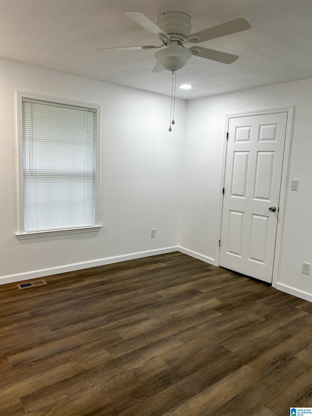 unfurnished room featuring ceiling fan and dark wood-type flooring