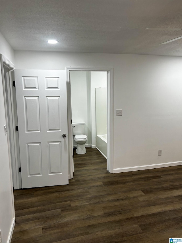 interior space with a textured ceiling and dark hardwood / wood-style flooring