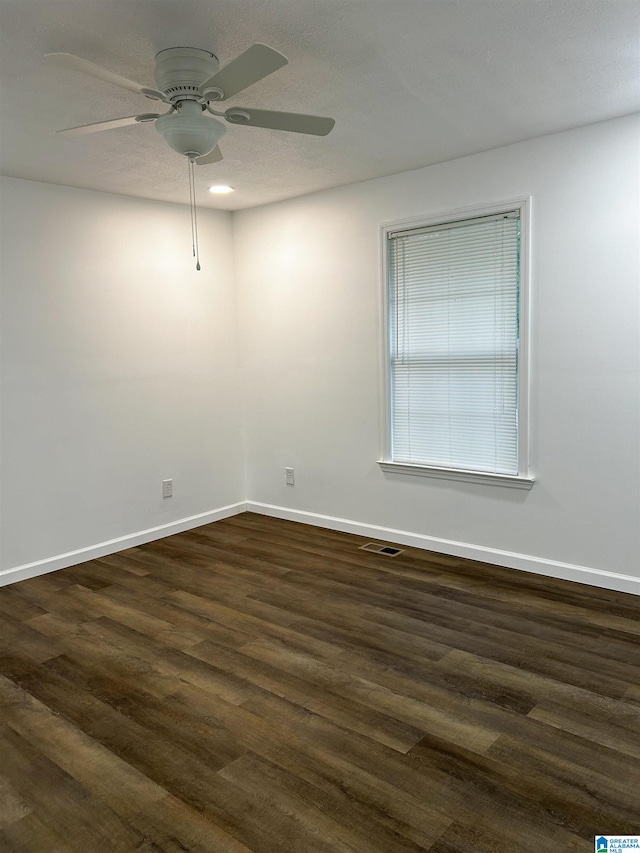 spare room featuring ceiling fan and dark hardwood / wood-style flooring