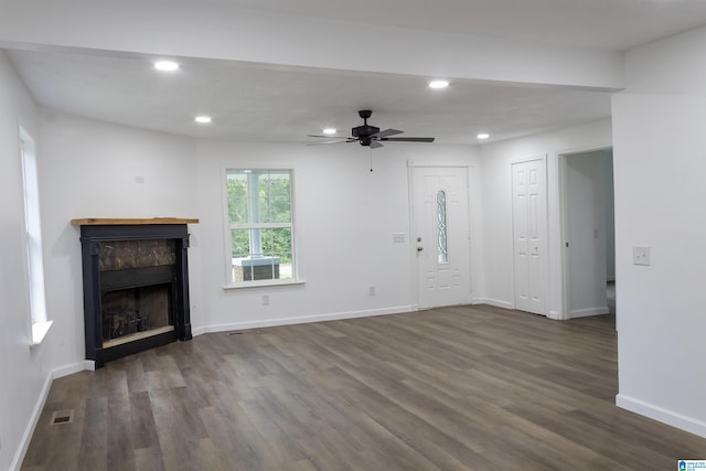 unfurnished living room featuring ceiling fan and dark hardwood / wood-style floors