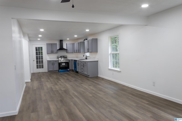 kitchen with appliances with stainless steel finishes, wall chimney exhaust hood, gray cabinets, dark hardwood / wood-style floors, and sink