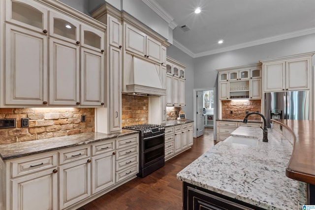 kitchen with sink, cream cabinetry, stainless steel appliances, dark hardwood / wood-style floors, and decorative backsplash