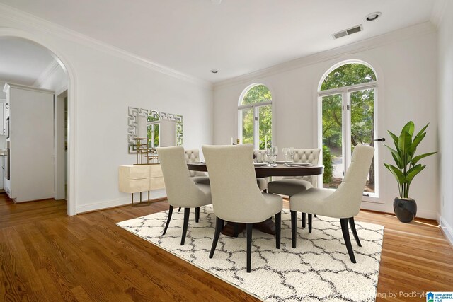 dining area with crown molding and hardwood / wood-style floors