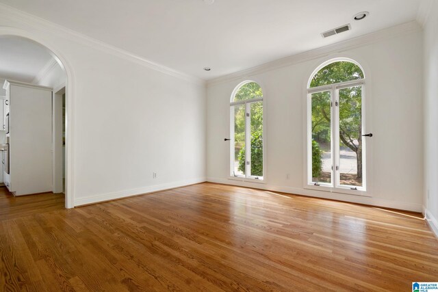 unfurnished room featuring ornamental molding and light hardwood / wood-style floors