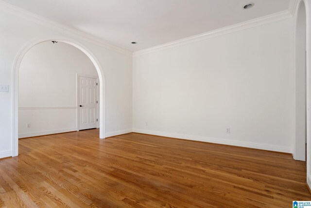 empty room featuring ornamental molding and hardwood / wood-style floors