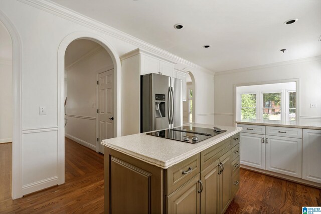 kitchen featuring stainless steel fridge, dark wood-type flooring, white cabinetry, a center island, and crown molding