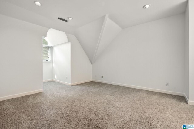 bonus room featuring carpet and vaulted ceiling