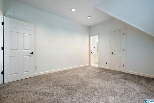 additional living space featuring carpet and vaulted ceiling