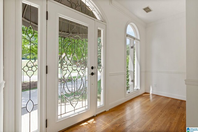 foyer with hardwood / wood-style flooring and crown molding