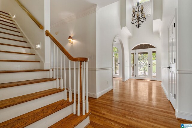 foyer featuring light wood-type flooring and a towering ceiling