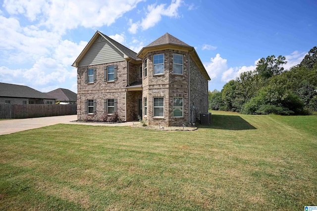 view of front of property with central AC and a front yard