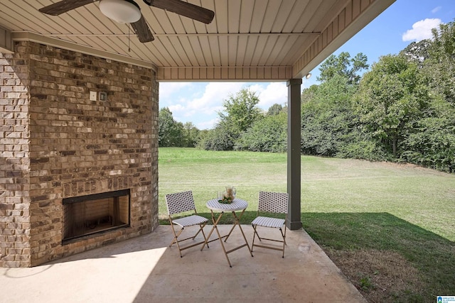 view of patio / terrace featuring ceiling fan and an outdoor brick fireplace