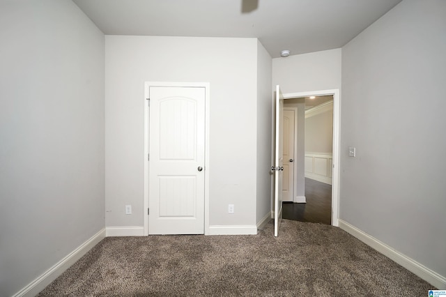 unfurnished bedroom with dark carpet