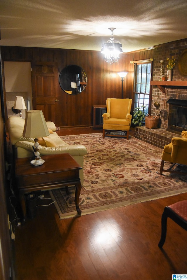 living room with wooden walls, a fireplace, hardwood / wood-style floors, and a textured ceiling