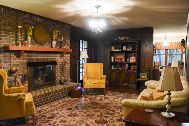 living room with brick wall, a fireplace, and a notable chandelier