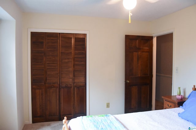 carpeted bedroom featuring ceiling fan and a closet