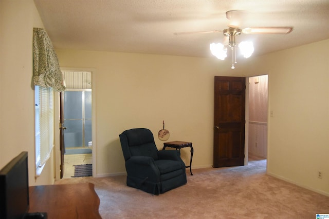 living area with ceiling fan and light colored carpet