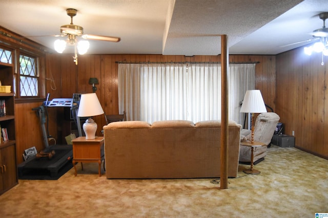 living room with carpet flooring, wood walls, and ceiling fan