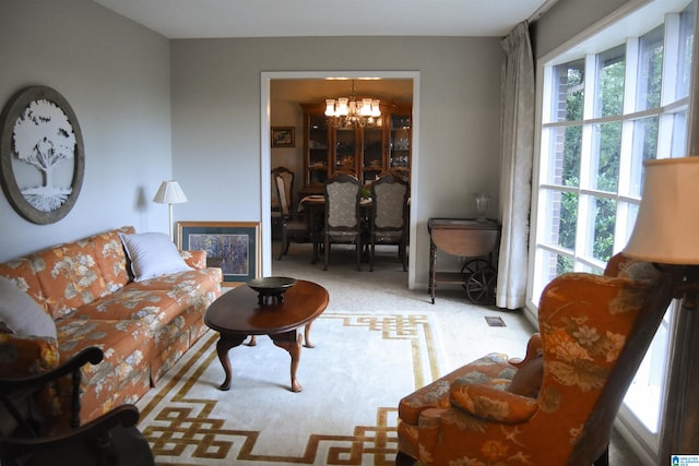 living room featuring a notable chandelier, light carpet, and a healthy amount of sunlight