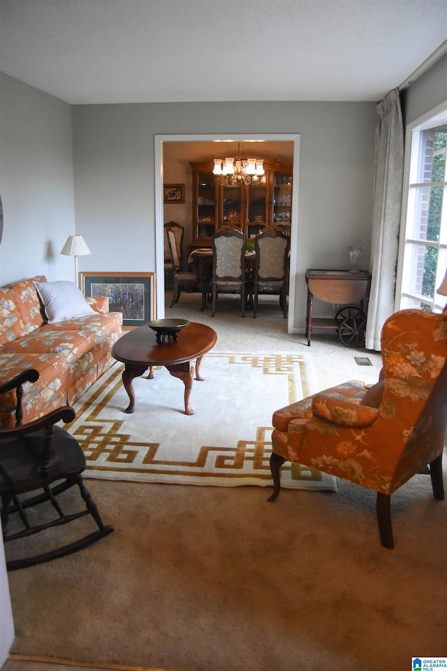 living room featuring light carpet and an inviting chandelier