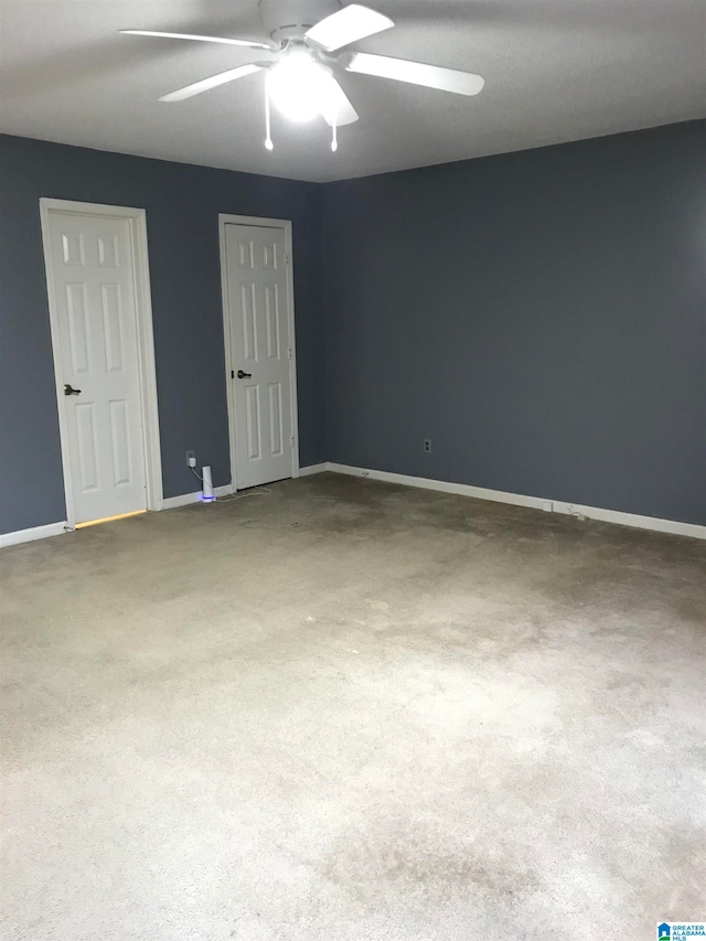 carpeted spare room with ceiling fan