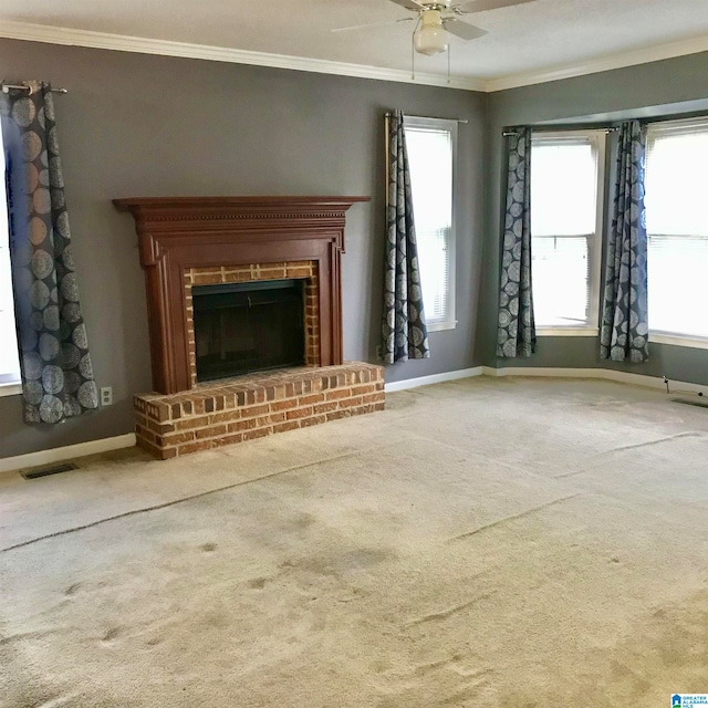 unfurnished living room with ceiling fan, carpet floors, a brick fireplace, and a healthy amount of sunlight