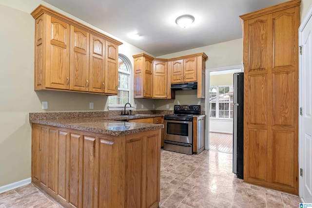 kitchen featuring stainless steel range with electric cooktop, black fridge, sink, and kitchen peninsula