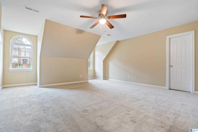 additional living space with ceiling fan, lofted ceiling, and light carpet